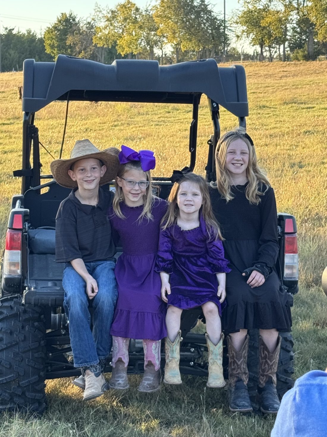 The Rigid Ranch kids in their boots at golden hour in Van Alstyne, Texas
