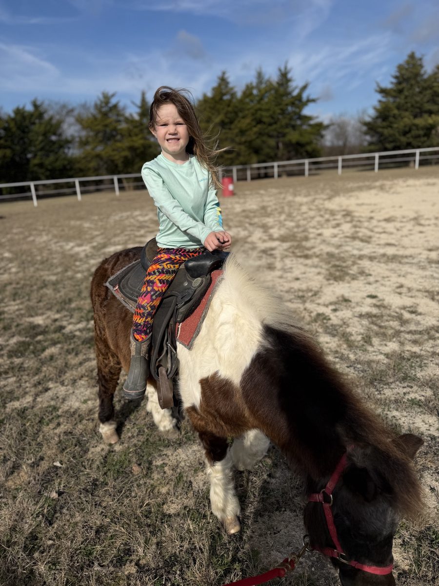 A young rancher riding a pony at Rigid Ranch